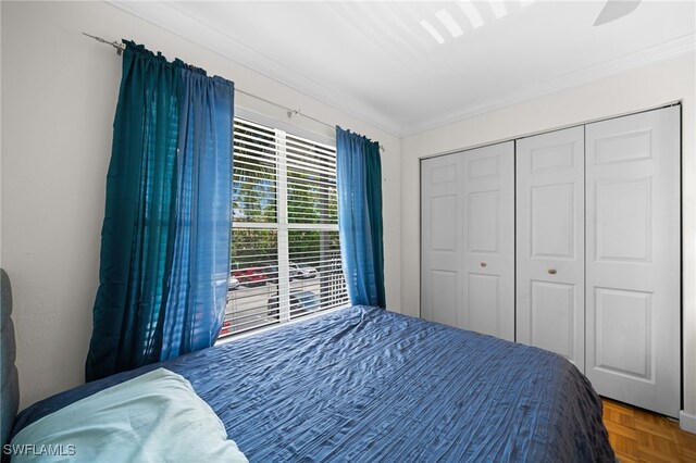 bedroom featuring parquet floors, ornamental molding, a closet, and ceiling fan