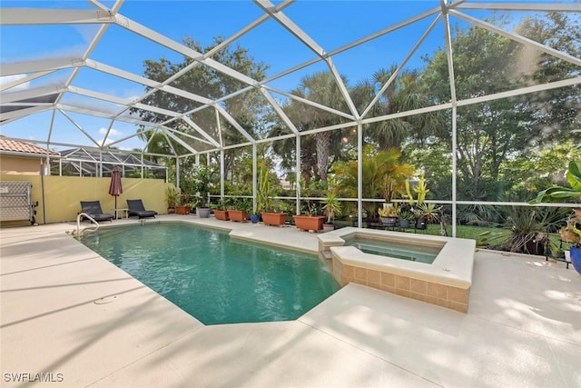 view of pool with glass enclosure, an in ground hot tub, and a patio