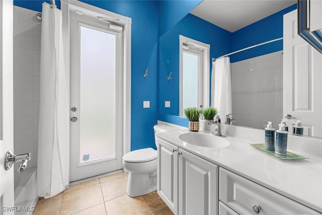 bathroom with plenty of natural light, toilet, vanity, and tile patterned flooring