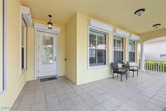 property entrance featuring covered porch and a wall mounted air conditioner