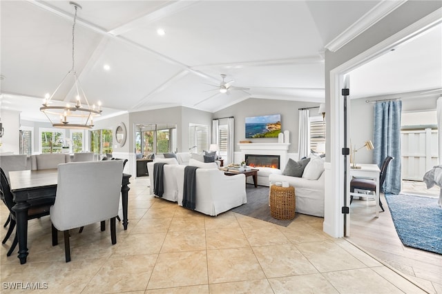 living room featuring ceiling fan with notable chandelier, light tile patterned floors, and lofted ceiling