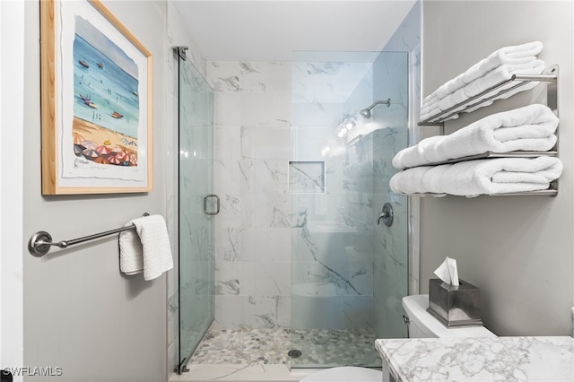 bathroom featuring toilet, vanity, and a shower with shower door