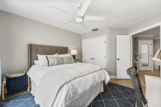 bedroom featuring dark hardwood / wood-style flooring, ceiling fan, crown molding, and a closet