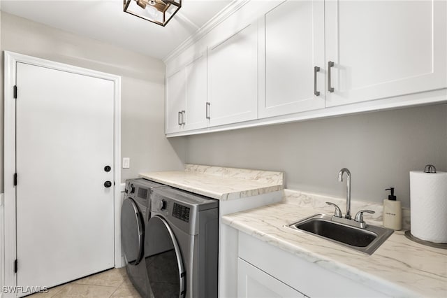 laundry area featuring cabinets, light tile patterned flooring, washer and clothes dryer, and sink