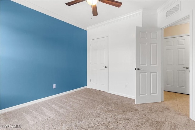 unfurnished bedroom with ceiling fan, a closet, light colored carpet, and ornamental molding