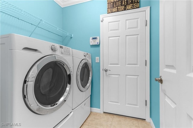 laundry area featuring separate washer and dryer, crown molding, and light tile patterned floors