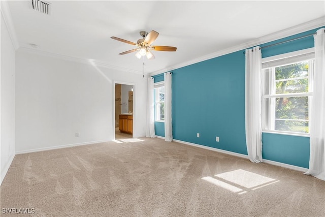 empty room with ceiling fan, a healthy amount of sunlight, ornamental molding, and carpet floors