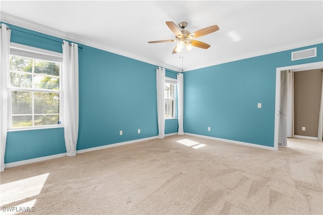 unfurnished room featuring ceiling fan, light colored carpet, and ornamental molding