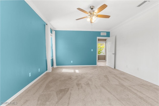 carpeted spare room with ceiling fan and ornamental molding