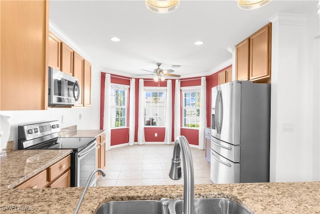 kitchen featuring sink, ceiling fan, light tile patterned floors, ornamental molding, and appliances with stainless steel finishes