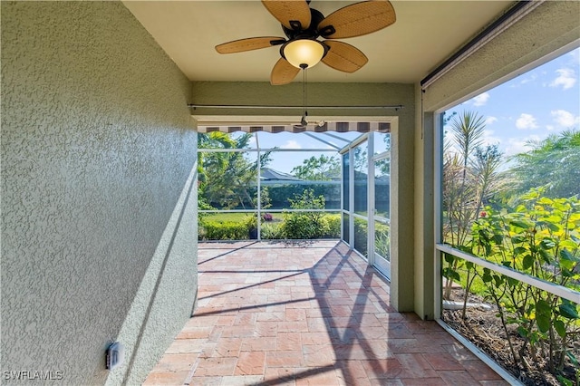 unfurnished sunroom featuring ceiling fan