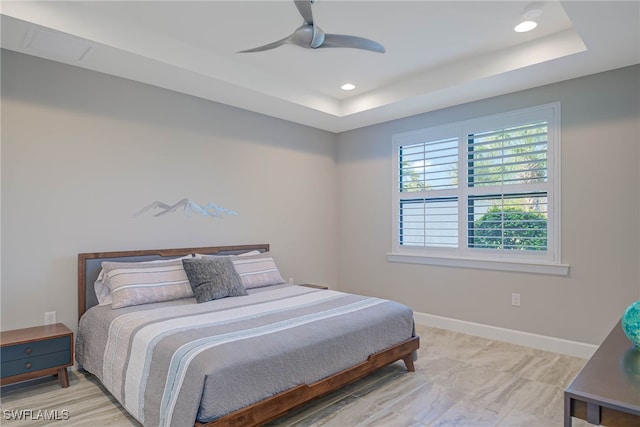 bedroom with a raised ceiling and ceiling fan