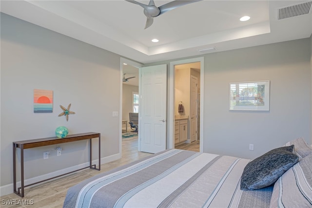 bedroom with multiple windows, connected bathroom, light hardwood / wood-style flooring, and ceiling fan