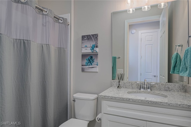 bathroom featuring vanity, toilet, and walk in shower