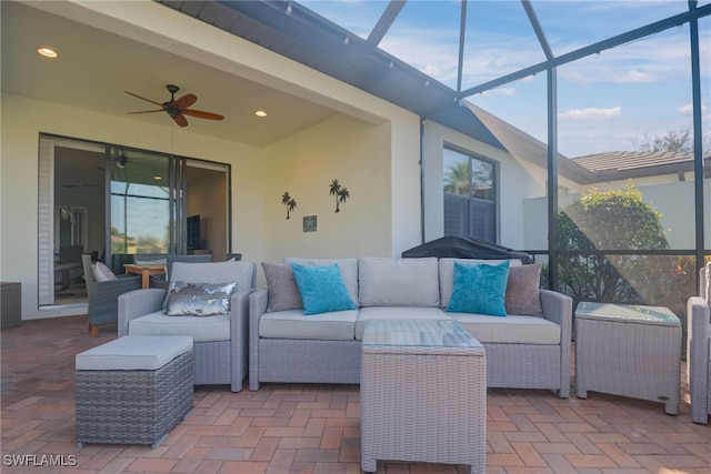 view of patio / terrace featuring glass enclosure, ceiling fan, and an outdoor living space