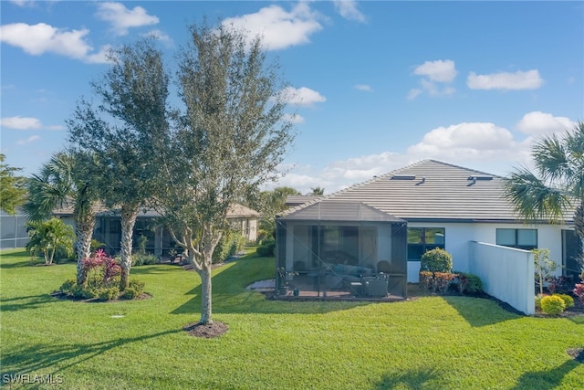 back of house with a yard and a lanai