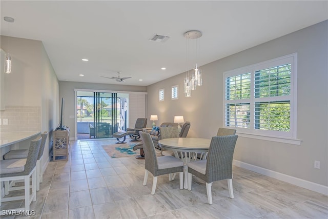 dining space with light tile patterned floors and ceiling fan with notable chandelier