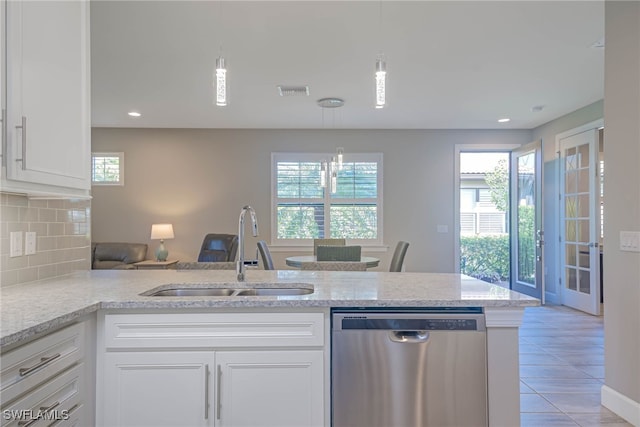 kitchen featuring white cabinetry, stainless steel dishwasher, hanging light fixtures, and sink