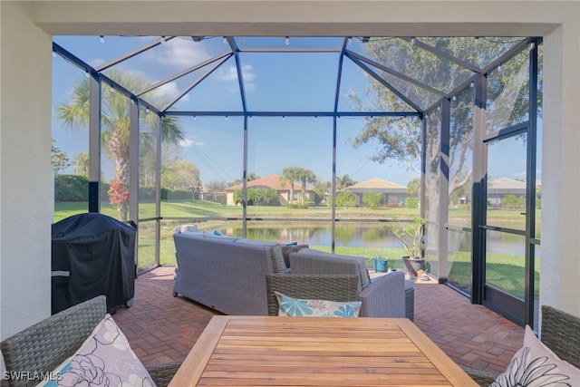 view of patio / terrace with a water view, area for grilling, and a lanai