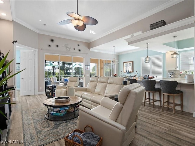 living room with ceiling fan, crown molding, and light wood-type flooring