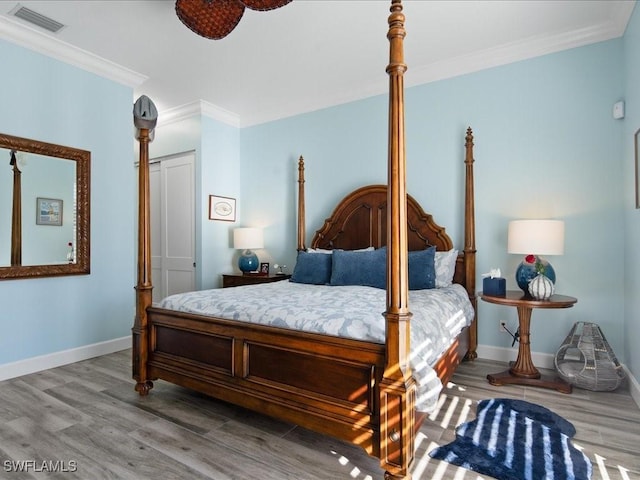 bedroom with ornamental molding, hardwood / wood-style floors, and a closet