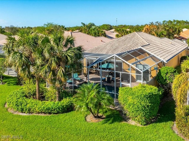 back of house with a lanai, a patio, and a yard