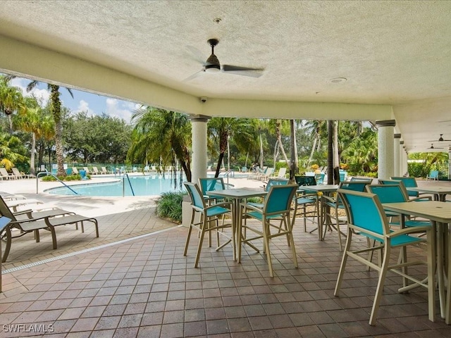 view of patio featuring ceiling fan and a community pool