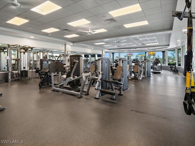 gym featuring ceiling fan and a drop ceiling