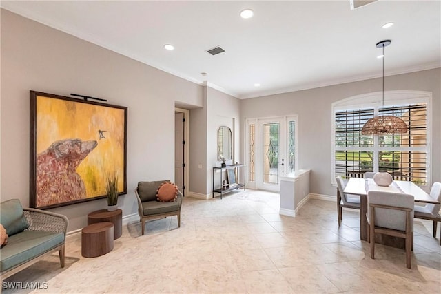 living area with crown molding and a notable chandelier