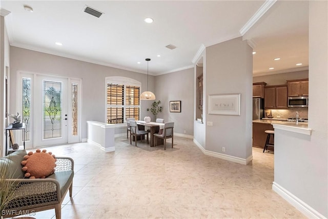 dining space featuring sink and ornamental molding