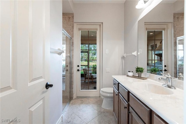 bathroom featuring toilet, vanity, tile patterned floors, and a shower with door