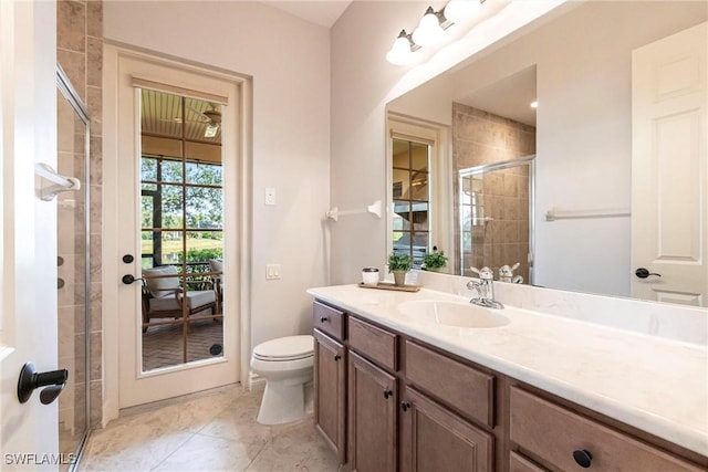 bathroom with toilet, vanity, tile patterned flooring, and an enclosed shower