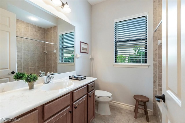 bathroom featuring toilet, vanity, tile patterned flooring, and tiled shower