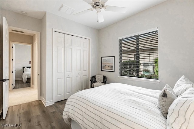 bedroom with dark wood-type flooring, a closet, and ceiling fan