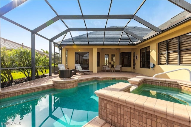 view of swimming pool with a lanai, an in ground hot tub, and a patio