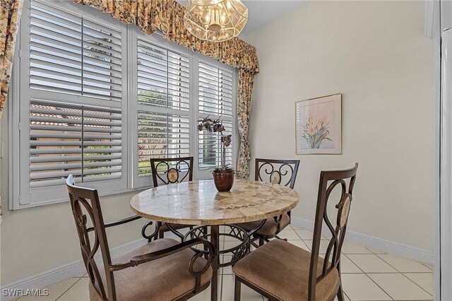 dining area with light tile patterned flooring and a chandelier