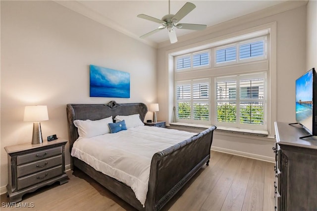 bedroom with crown molding, light hardwood / wood-style floors, and ceiling fan