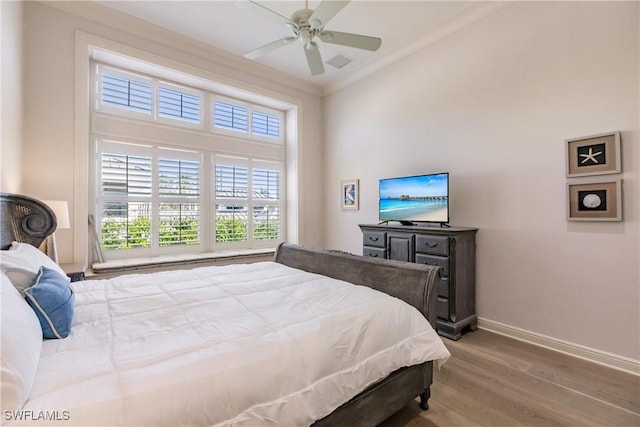 bedroom featuring hardwood / wood-style floors, ornamental molding, and ceiling fan