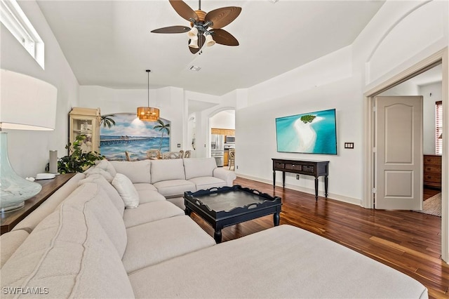 living room with ceiling fan and dark wood-type flooring