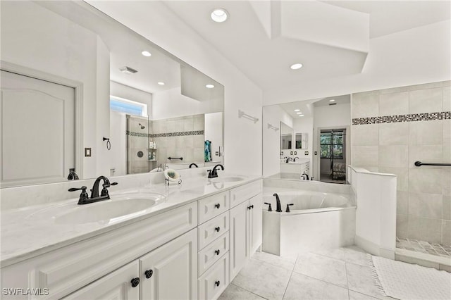 bathroom with vanity, tile patterned flooring, and plus walk in shower