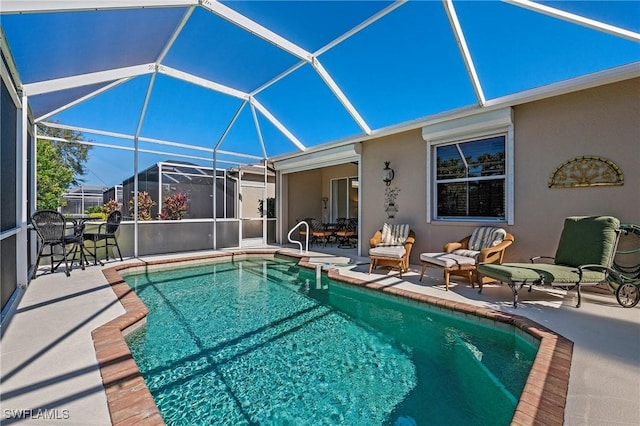 view of pool with a patio and glass enclosure