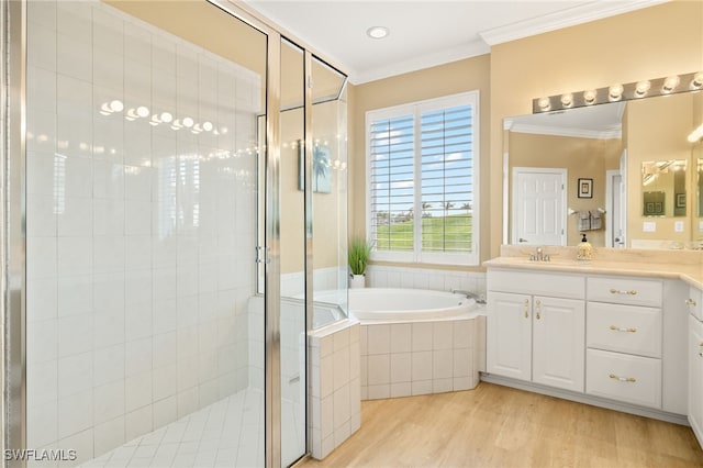 bathroom featuring separate shower and tub, ornamental molding, hardwood / wood-style flooring, and vanity