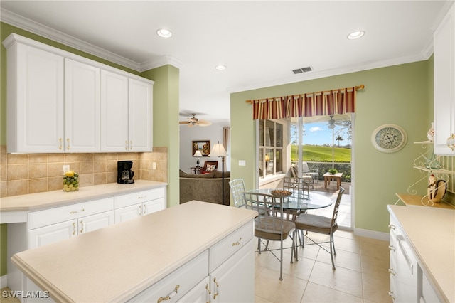 kitchen with ceiling fan, white cabinets, and backsplash