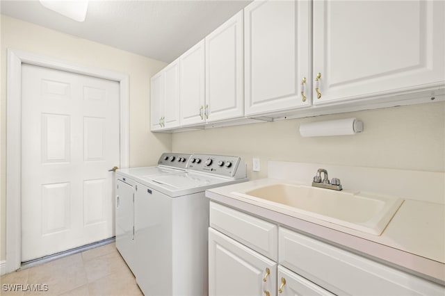 laundry room featuring independent washer and dryer, light tile patterned flooring, sink, and cabinets