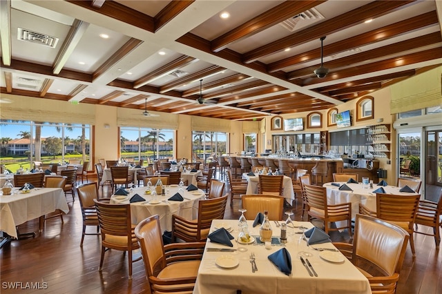 dining space with dark hardwood / wood-style floors, beamed ceiling, and coffered ceiling