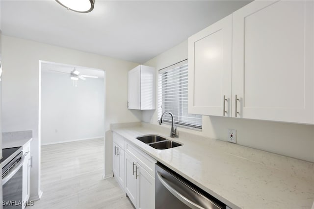 kitchen featuring white cabinets, light stone counters, sink, and appliances with stainless steel finishes