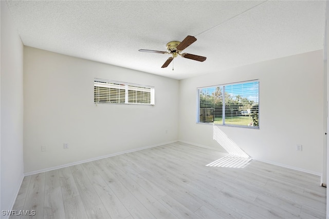 spare room featuring a textured ceiling, light hardwood / wood-style flooring, and ceiling fan