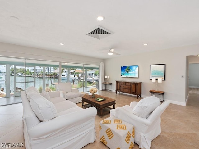 living area with baseboards, a water view, visible vents, and recessed lighting