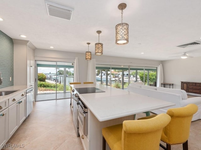 kitchen featuring a kitchen island, visible vents, stainless steel appliances, and light countertops