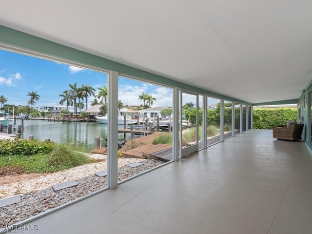 unfurnished sunroom featuring plenty of natural light and a water view